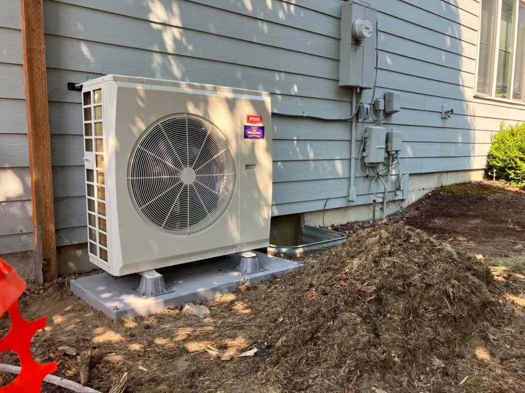 A sleek Bryant condenser sits outside on a concrete pad with Heat Pump Services Greater Puget Sound.