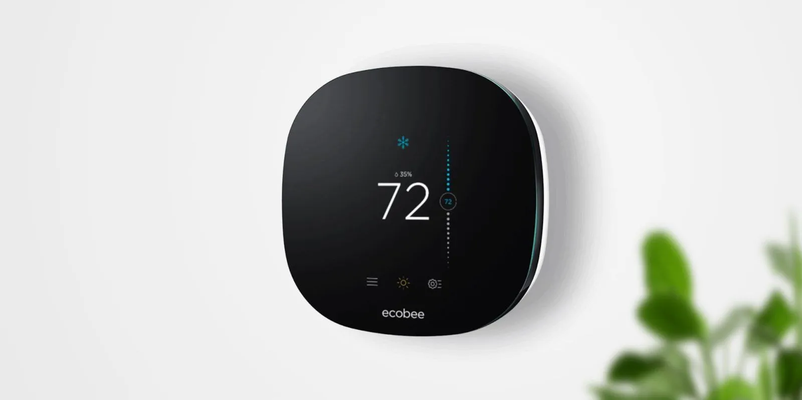 Black Ecobee smart thermostat displaying 72 degrees mounted on a clean white indoor wall.