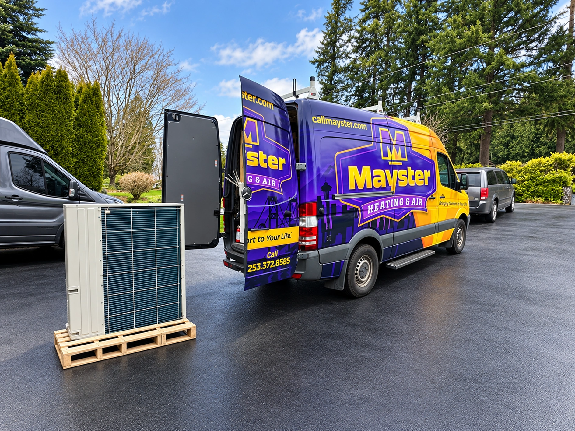 A purple and yellow HVAC service van with open back doors parked next to a new heat pump unit on a wooden pallet outdoors.