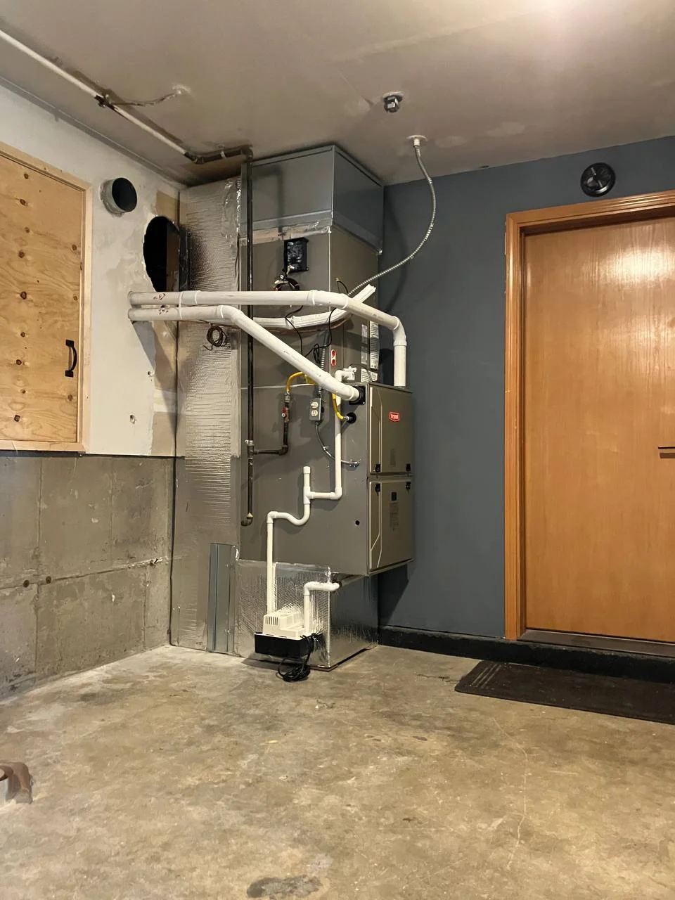 A gray and silver HVAC unit installed in a utility room by certified Heating System Services Greater Puget Sound.