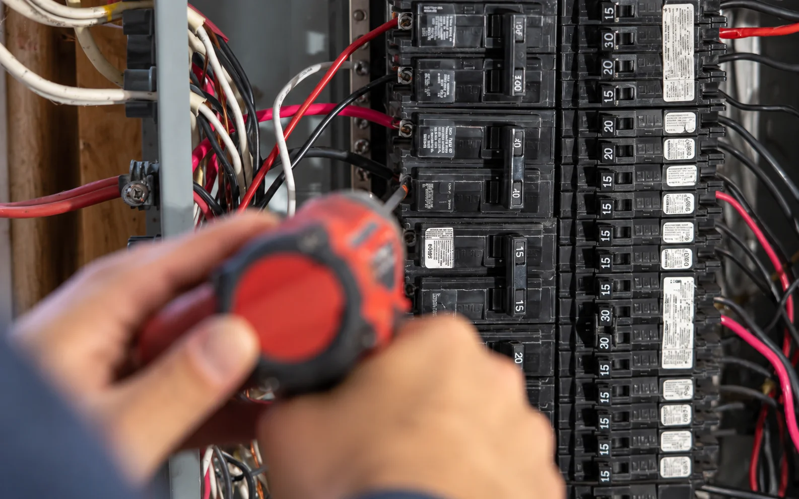 An electrician using a screwdriver during an Electrical Panel Replacement Greater Puget Sound project.