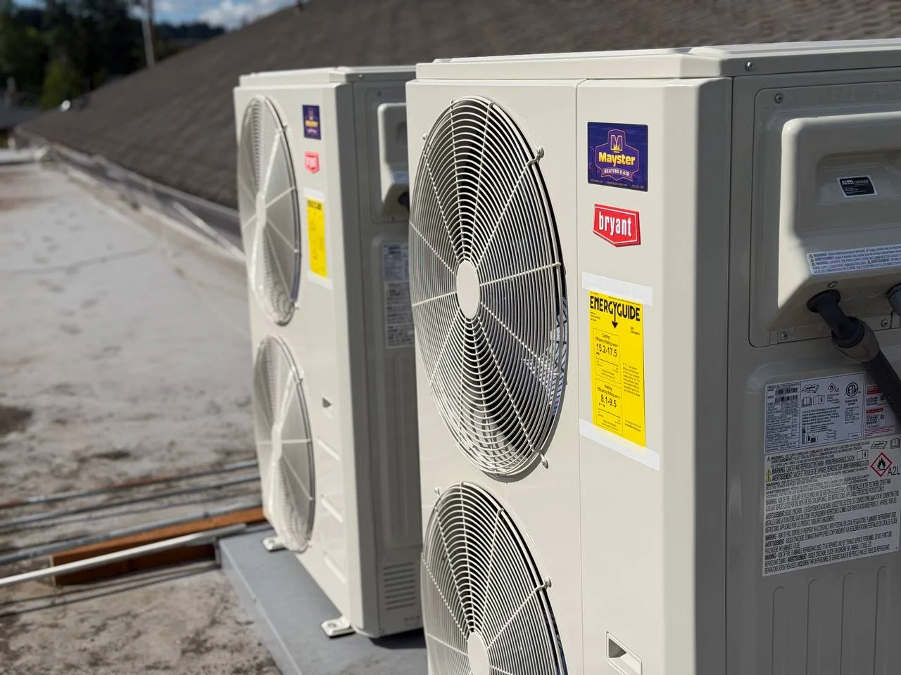 Two commercial HVAC units stand side by side on a flat roof thanks to Heat Pump Services Greater Puget Sound.