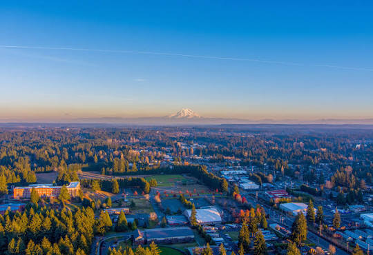Aerial view of Lacey neighborhoods at sunset with mountains in the distance, a community where Mayster offers HVAC services in Lacey WA to homeowners