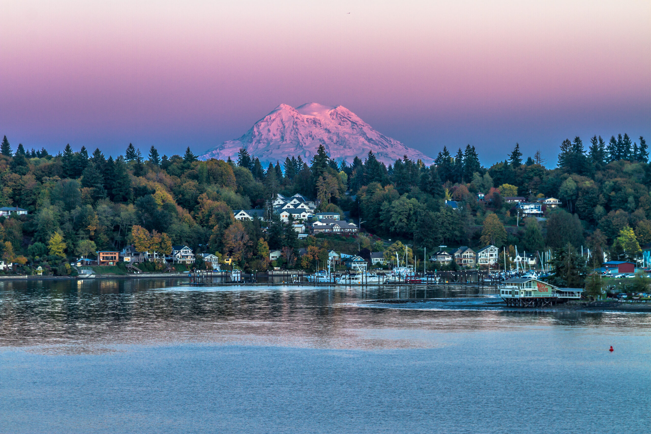 Mount Rainier glowing at dusk above homes and boats along Budd Inlet, where Mayster provides HVAC services in Olympia WA for local homes