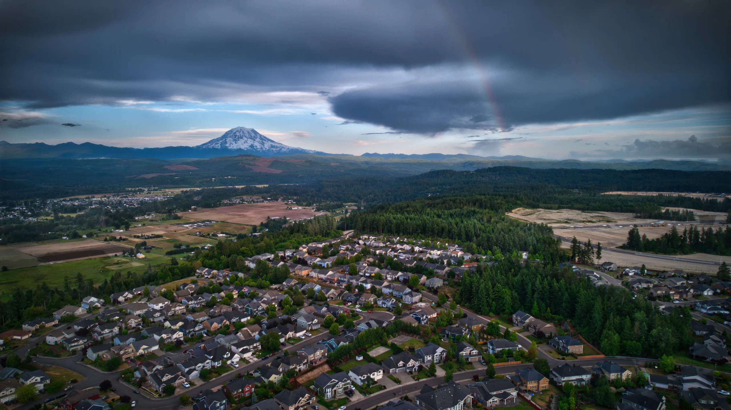 Aerial view of Orting neighborhoods in the valley under cloudy skies, where Mayster delivers HVAC services in Orting WA to nearby families