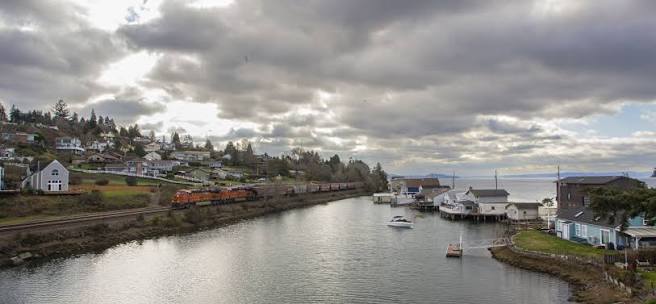 Calm waterway and shoreline in University Place under a cloudy sky, where Mayster delivers HVAC services in University Place WA to nearby families