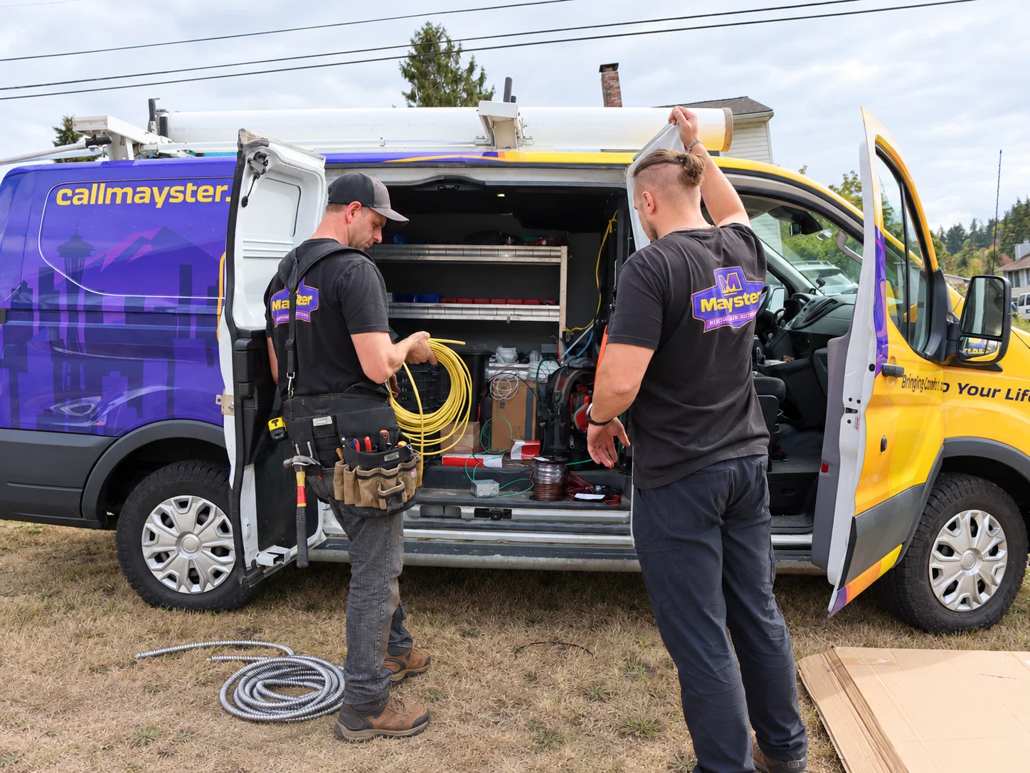 Two electricians retrieve yellow wiring for reliable Electrical Diagnostics Greater Puget Sound service outdoors.