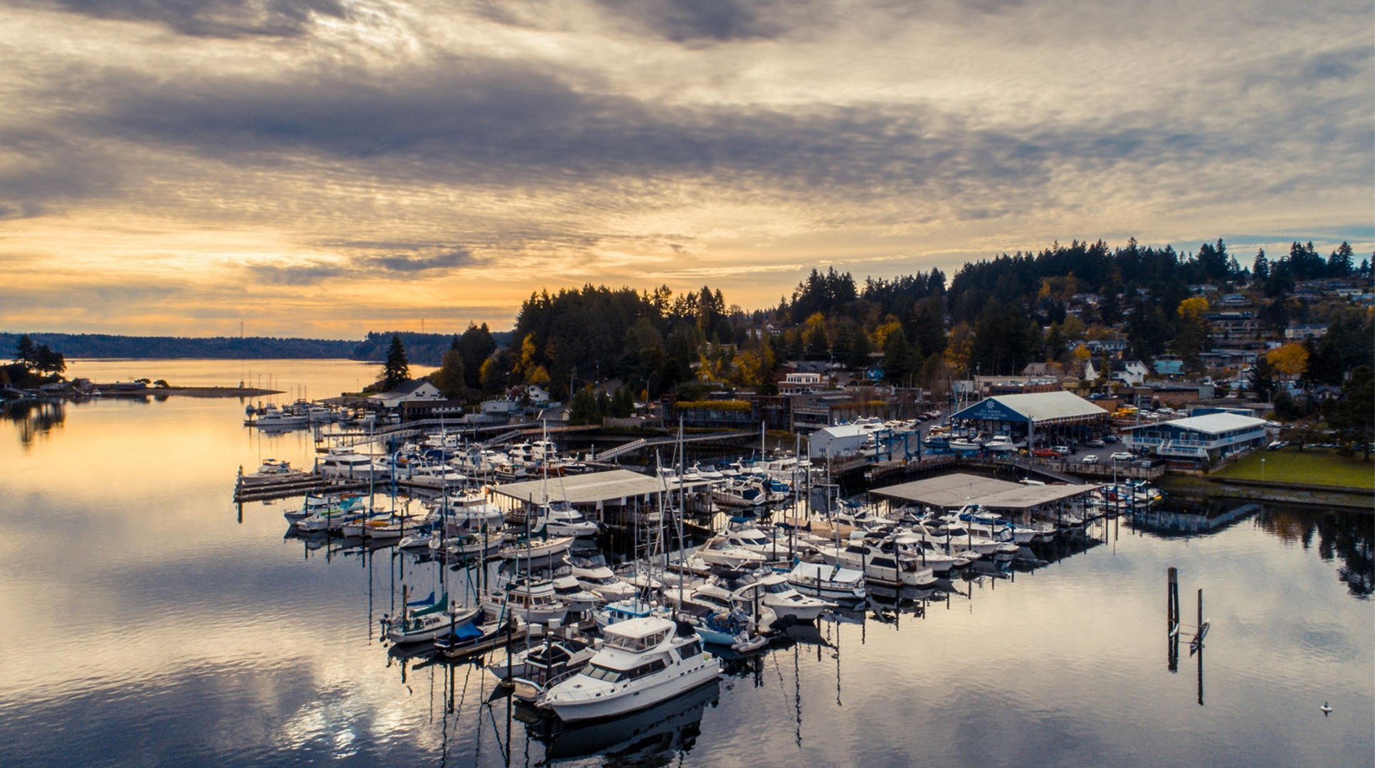 Boats moored in the Gig Harbor marina under a golden sunset sky, a waterfront town where Mayster offers HVAC services in Gig Harbor WA to local homes