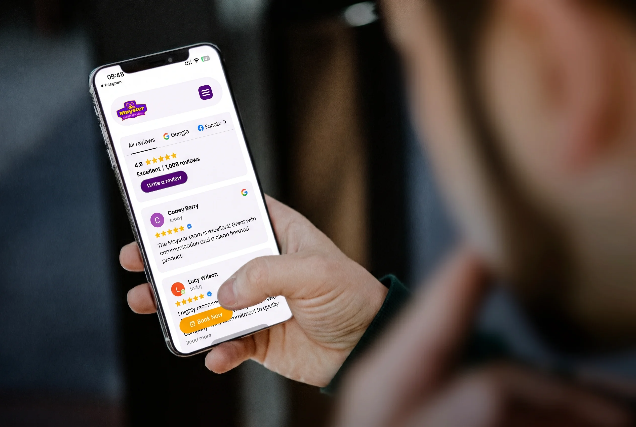 A man checking Mayster Heating Air Electric reviews on his phone to read feedback about their HVAC and electrical work.