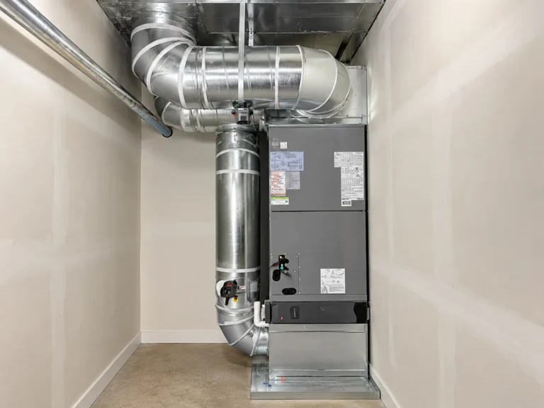 Large gray HVAC unit connected to extensive metal ductwork in a utility room, finished as part of an air handler installation Greater Puget Sound.